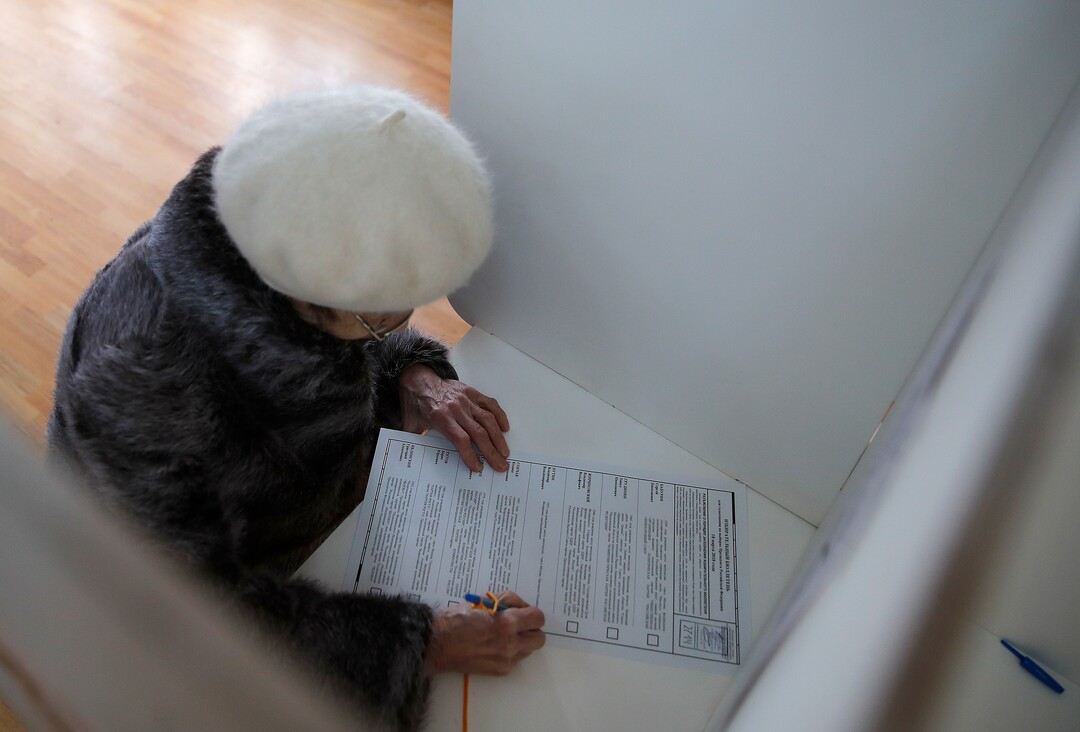 A woman prepares to cast her ballot in the presidential election in Moscow, Russia, Sunday, March 18, 2018. Russians are voting in a presidential election in which Vladimir Putin is seeking a fourth term in the Kremlin. (AP Photo/Pavel Golovkin)