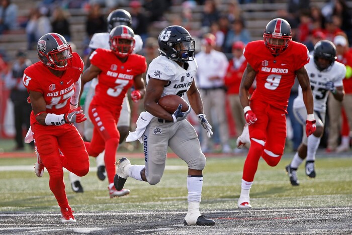 Utah State running back LaJuan Hunt, center, sprints to the end zone ahead of the New Mexico on a 65-yard touchdown run during the first half of an NCAA college football game in Albuquerque, N.M., Saturday, Nov. 4, 2017. (AP Photo/Andres Leighton)