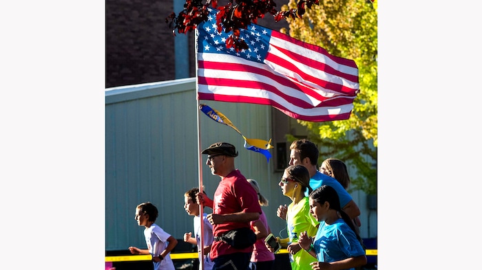 (Rick Egan | The Salt Lake Tribune) Paul Hubenthal carries the American Flag as he runs in the Layton Fun Run, during the Layton Liberty Days Celebration, on Monday, July 5, 2021.