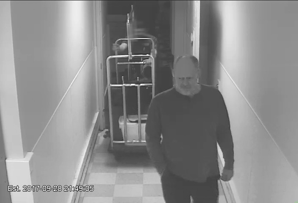 In this Sept. 28, 2017, security camera image released by MGM Resorts, Stephen Paddock is followed by a bellman in a hallway, at the Mandalay Bay hotel in Las Vegas. The newly released video shows the man who killed 58 people on the Las Vegas Strip moving around a casino before the attack, gambling, bringing suitcases into his room at Mandalay Bay but doing nothing that would obviously raise suspicions. (MGM Resorts via AP)
