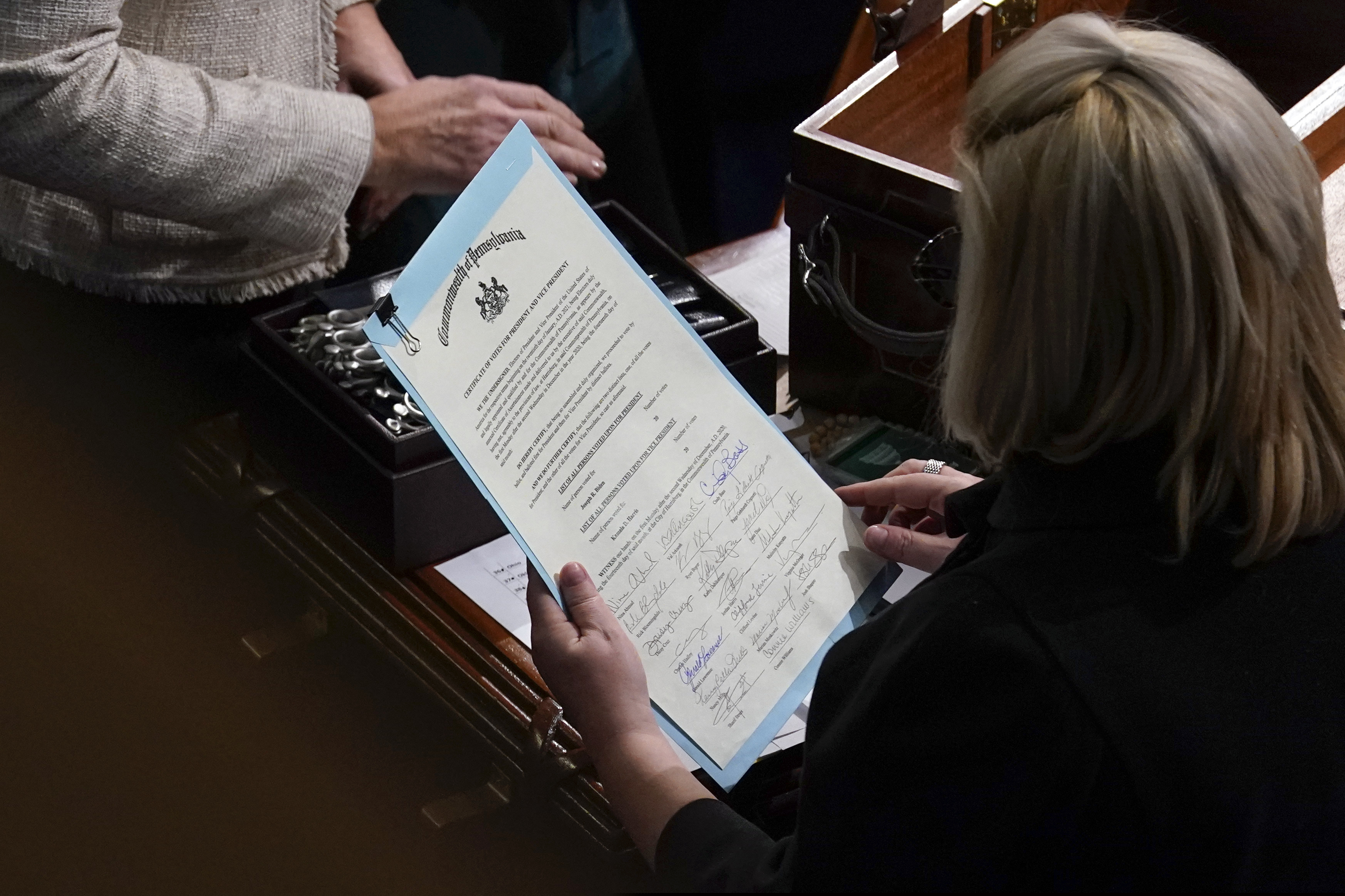 (Andrew Harnik | AP photo)
In this Jan. 7, 2021, file photo the signed certificate of Electoral College votes from Pennsylvania is held by a staff member during a joint session of the House and Senate to confirm the Electoral College votes cast in November's election, at the Capitol, in Washington.