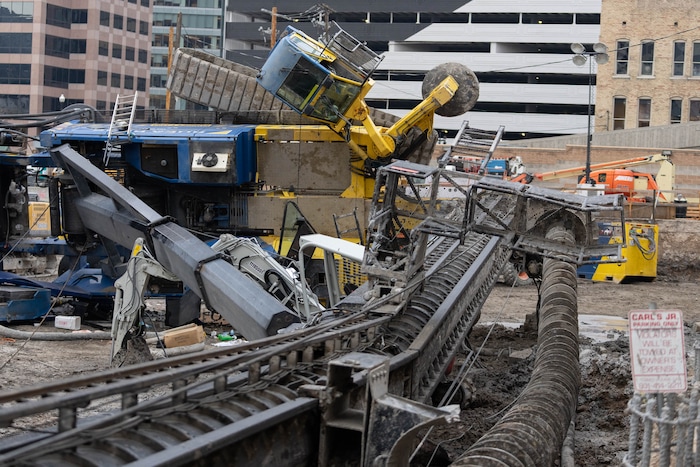 (Francisco Kjolseth | The Salt Lake Tribune) A collapsed drill rig is seen on Wednesday, March 16, 2022, at the intersection of State Street and 200 South. The rig toppled over Tuesday night at the site of the new Astra Tower, crushing two unoccupied parked cars and sending the crane operator to the hospital in serious condition.