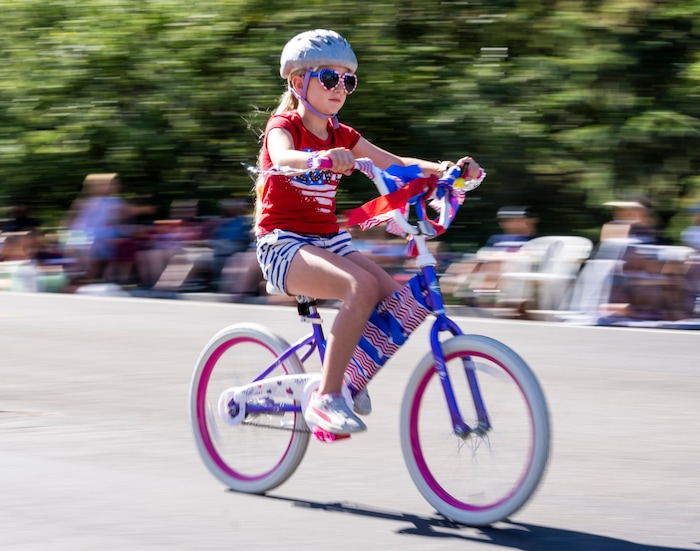 (Rick Egan | The Salt Lake Tribune) A young girl rides  in the Kids Bike parade, during the Cherry Days Fourth of July Celebration, in North Ogden, on Monday, July 4, 2022.