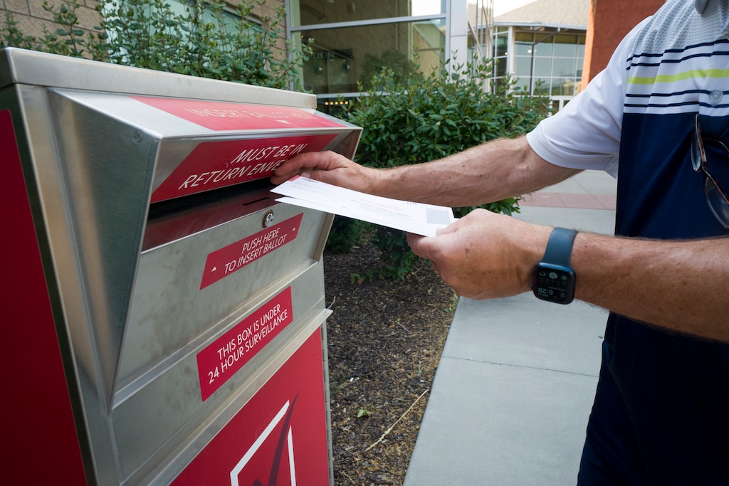 (Bethany Baker  |  The Salt Lake Tribune) A voter drops off two ballots at a ballot drop box at the Davis Conference Center in Layton on Monday, June 22, 2026.