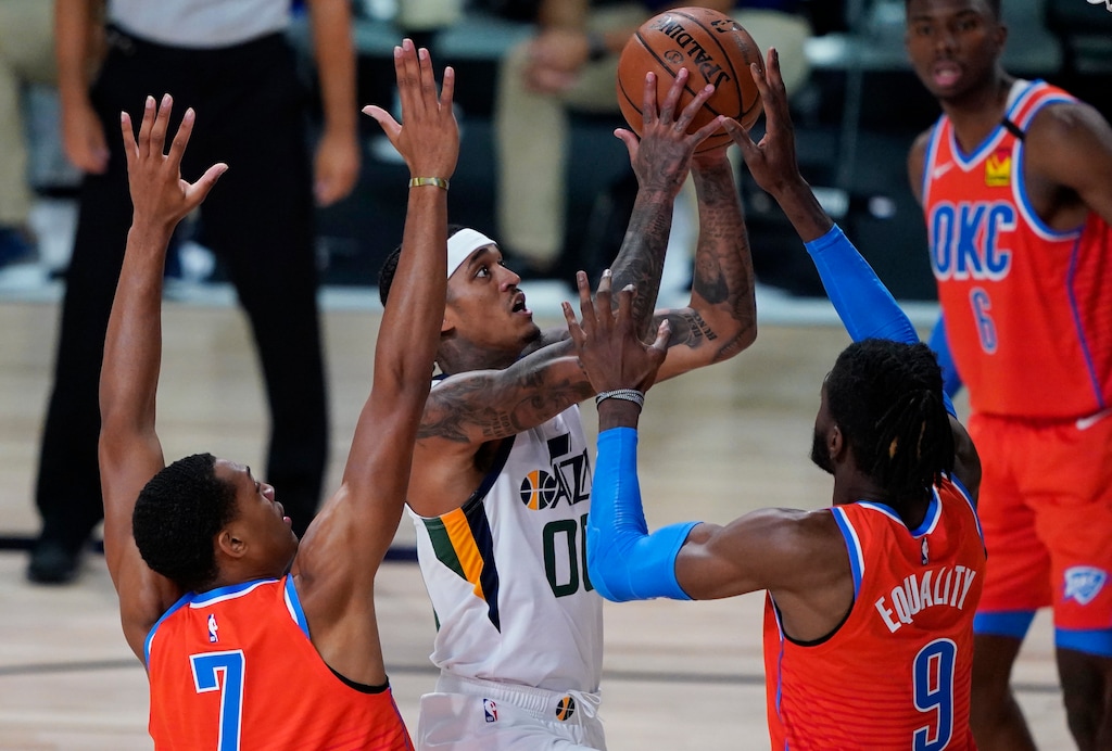 Utah Jazz's Jordan Clarkson (00) shoots around Oklahoma City Thunder's Nerlens Noel, right, and Darius Bazley, left, during the second half of an NBA basketball game Saturday, Aug. 1, 2020, in Lake Buena Vista, Fla. (AP Photo/Ashley Landis, Pool)