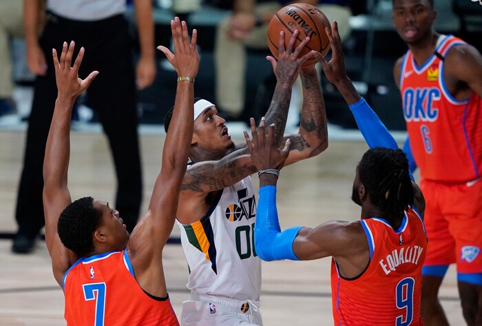 Utah Jazz's Jordan Clarkson (00) shoots around Oklahoma City Thunder's Nerlens Noel, right, and Darius Bazley, left, during the second half of an NBA basketball game Saturday, Aug. 1, 2020, in Lake Buena Vista, Fla. (AP Photo/Ashley Landis, Pool)