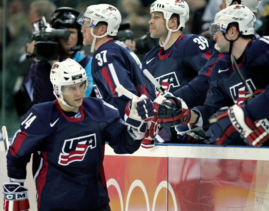 FILE - In this Feb. 15, 2006, file photo, United States' Brian Gionta (14) is congratulated by teammates after scoring against Latvia during a 2006 Winter Olympics men's ice hockey match, in Turin, Italy. When Gionta last played in the Olympics in 2006, his final NHL game before the break allowed him just three days to fly to Italy and get acclimated before suiting up for the United States. It won’t be so much of a whirlwind this time around for the semi-retired U.S. captain and his Olympic teammates, who will get four whole practice days before opening the tournament against Slovenia on Feb. 14. (AP Photo/Gene J. Puskar, File)