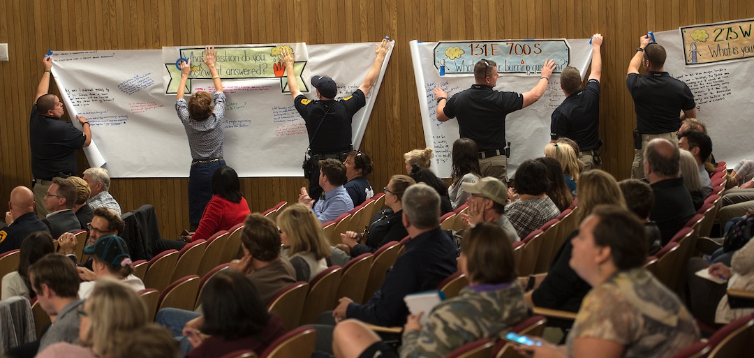 (Leah Hogsten  |  The Salt Lake Tribune) Salt Lake City police officers tack questions written by the public for  Salt Lake City community leaders and service providers to answer during a public forum, Tuesday, September 26, 2017 to present preliminary designs and programming for the two new Homeless Resource Centers to be located at 131 E 700 S and 275 W High Ave. in Salt Lake City. 