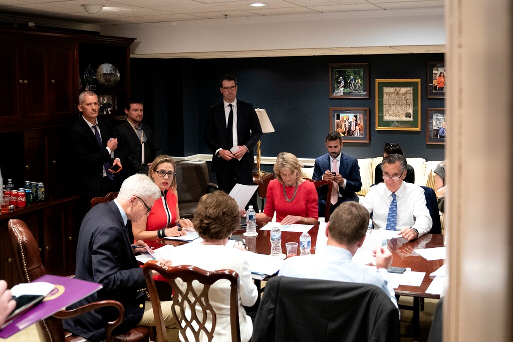 (Stefani Reynolds | The New York Times) A bipartisan group of Senators, including Sens. Bill Cassidy (R-La.), seated from left, Kyrsten Sinema (D-Ariz.), Lisa Murkowski (R-Alaska, and Mitt Romney (R-Utah), meet to discuss a new infrastructure package in one of the offices of Sen. Rob Portman (R-Ohio), at the Capitol in Washington on Tuesday, June 8, 2021.