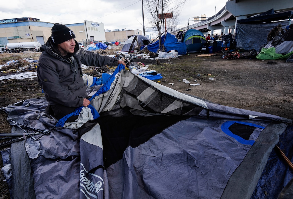 (Rick Egan | The Salt Lake Tribune)  Tony Lambert helps dismantle a tent for a friend during a camp abatement in Salt Lake City on Thursday, Feb. 17, 2022. The city has extended a moratorium on providing more shelters or resource centers for unsheltered individuals.
