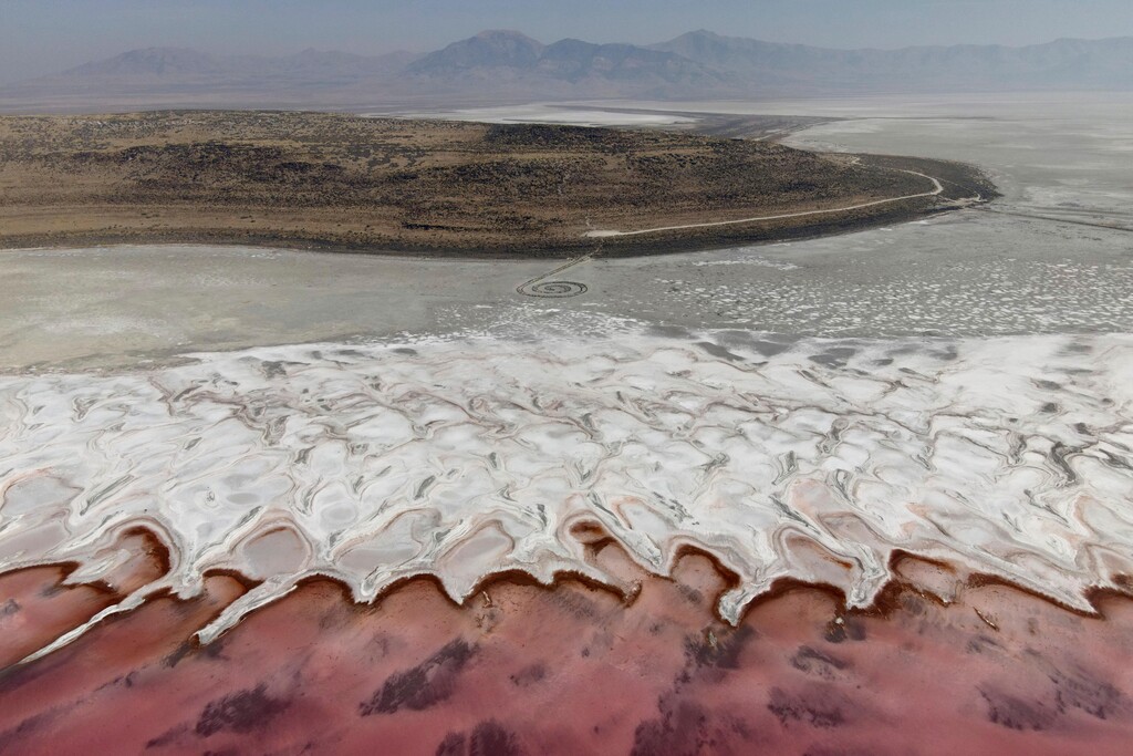 (Julio Cortez | AP file photo) In a photo taken from a drone, a reddish tint is seen near the Spiral Jetty along the shore of the Great Salt Lake, Oct. 8, in Howell, Utah. The red hue of the North Arm of the lake comes from a type of bacteria, known as halophilic bacteria, that flourishes when the salt level rises.