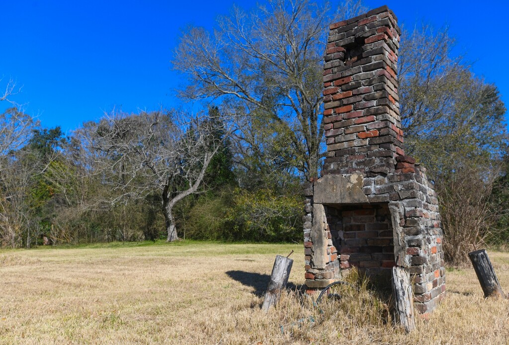 FILE - In this Tuesday, Jan. 29, 2019, file photo, a chimney, the last remaining original structure from the days when survivors of the Clotilda, the last known slave ship brought into the United States, inhabited the area, stands in an abandoned lot in Africatown in Mobile, Ala. On Wednesday, May 22, 2019, authorities said that researchers have located the wreck of Clotilda. (AP Photo/Julie Bennett, File)