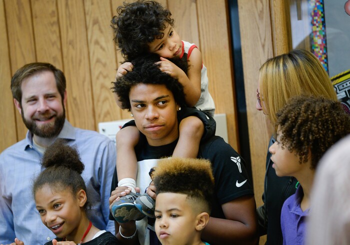 (Francisco Kjolseth  |  The Salt Lake Tribune)  Kearns High sophomore Keeven Wilson, 16, with brother Kinston, 3, on top, gathers for family photos after being announced as Granite School District's Absolutely Incredible Kid award winner during the school farewell assembly on Tuesday, May 22, 2018. Wilson who had a particularly difficult home life, to the point that he and his siblings were taken away from his parents and near universal F's during his junior high days, turned his life around.  With the help of a new foster family, teachers and his football coach, he is now an honor roll student and thinking of studying psychology in college.