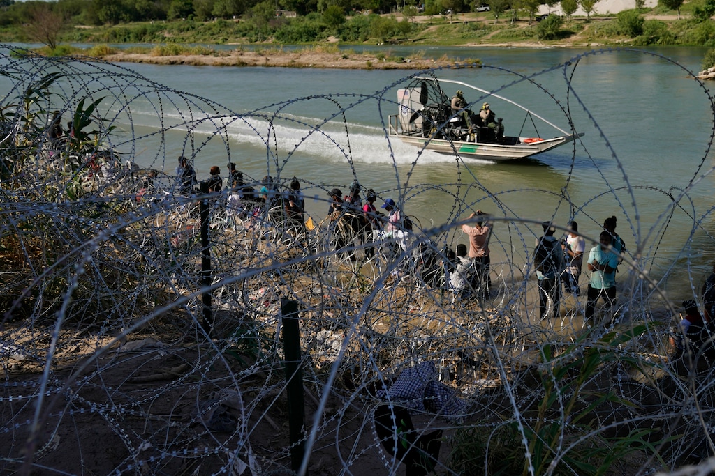 (Eric Gay | AP) Migrants who crossed into the U.S. from Mexico are met with concertina wire along the Rio Grande, Sept. 21, 2023, in Eagle Pass, Texas. Utah Gov. Spencer Cox has endorsed Texas's effort to ignore the Supreme Court over the southern border crisis.