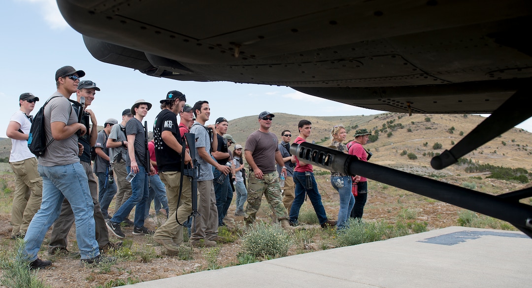 (Leah Hogsten  |  The Salt Lake Tribune) Attendees walk towards an  AH-64 Apache Attack helicopter from the 211th Aviation Group during the Utah National Guard Special Forces Survival Training Experience, August 10-12 at Camp Williams.