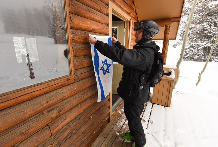 (Francisco Kjolseth | The Salt Lake Tribune) Rabbi David Levinsky, spiritual leader at Park City's Temple Har Shalom, tacks an Israeli flag to Sunset Cabin at Deer Valley Resort, affectionately referred to as "Ski Shul," by its members. The visual cue lets skiers know that Friday's afternoon service on the mountain is about to begin.