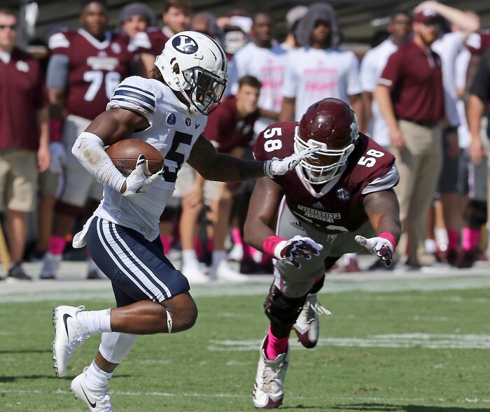 Brigham Young defensive back Dayan Ghanwoloku (5) runs back an intercepted pass past Mississippi State offensive lineman Greg Eiland (58) during the second half of an NCAA college football game in Starkville, Miss., Saturday, Oct. 14, 2017. Mississippi State won 35-10. (AP Photo/Jim Lytle)