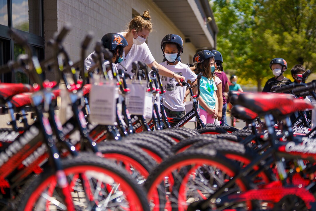 (Trent Nelson  |  The Salt Lake Tribune) Abbi Arneson, a volunteer with the non-profit Can’d Aid, helps to hand out sixty bikes to 1st grade students at Mary W. Jackson Elementary in Salt Lake City on Thursday, May 13, 2021.