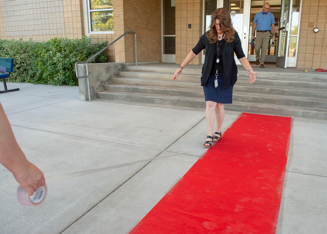 (Rick Egan  |  The Salt Lake Tribune)         Jeri Rigby, the new principal of Copperview Elementary School, tapes down the red carpet, on the first day of school, Monday, Aug. 19, 2019.