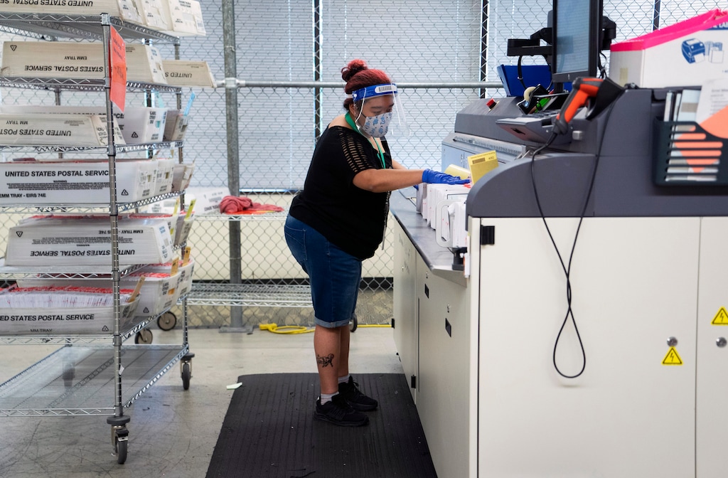 (Ruth Fremson | The New York Times) Kamisha Baseden processes mail-in ballots during the primary election in Renton, Wash., on Aug. 4, 2020. The Postal Service has warned states that it may not be able to meet their deadlines for delivering last-minute mail-in ballots, another development in a growing controversy over the new postmaster general’s handling of vote-by-mail operations as President Donald Trump continues to rail against the practice.