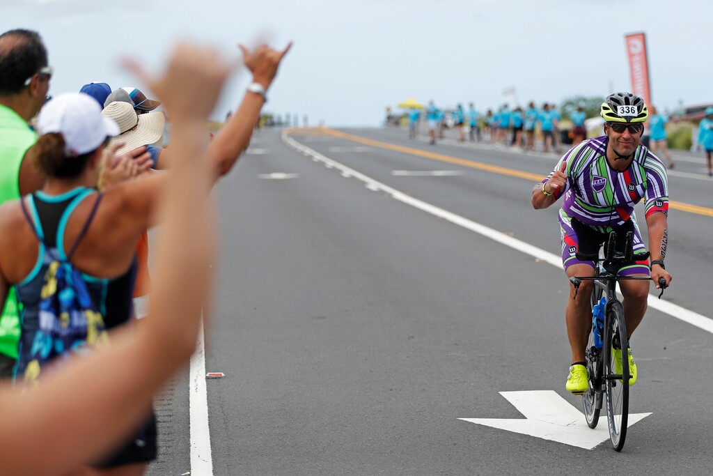 (Marco Garcia | AP) Onlookers cheer on the athletes on the course at the Ironman World Championship Triathlon, Saturday, Oct. 12, 2019, in Kailua-Kona, Hawaii.
