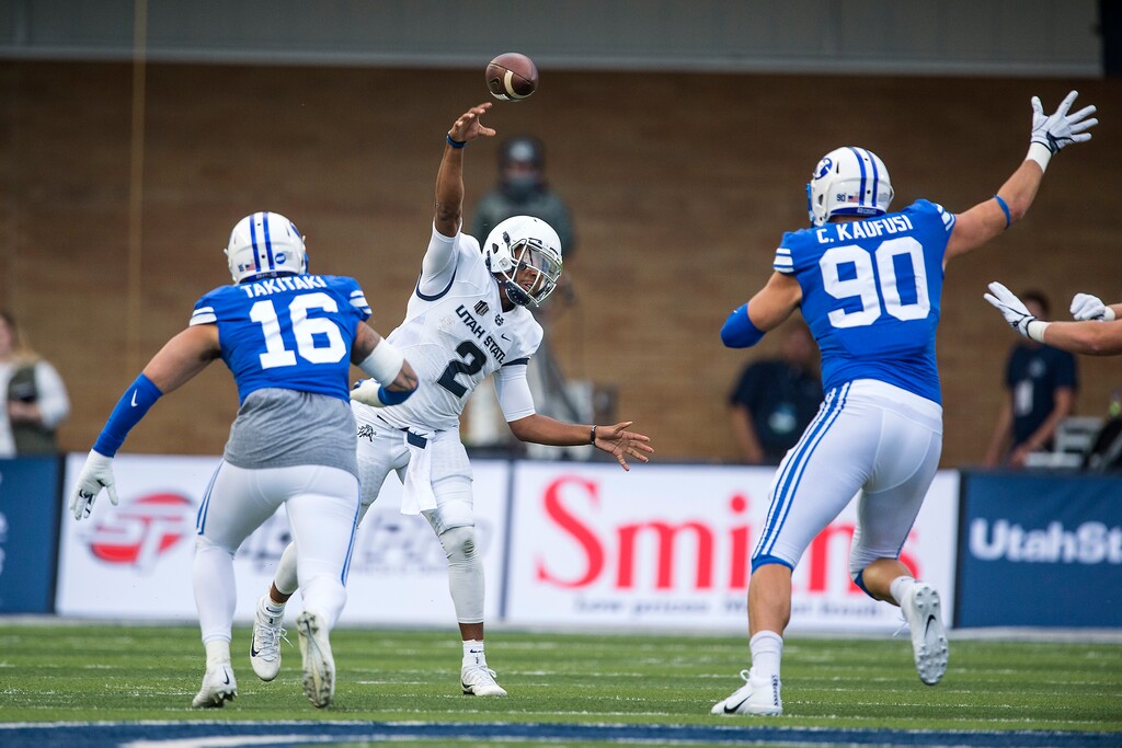 (Chris Detrick | The Salt Lake Tribune) Utah State Aggies quarterback Kent Myers (2) throws the ball past Brigham Young Cougars defensive lineman Sione Takitaki (16) and Brigham Young Cougars defensive lineman Corbin Kaufusi (90) during the game at Merlin Olsen Field at Maverik Stadium Friday, September 29, 2017.