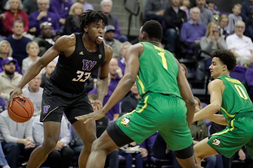 Washington forward Isaiah Stewart (33) looks to pass against Oregon center N'Faly Dante (1) and guard Will Richardson, right, during the first half of an NCAA college basketball game, Saturday, Jan. 18, 2020, in Seattle. (AP Photo/Ted S. Warren)