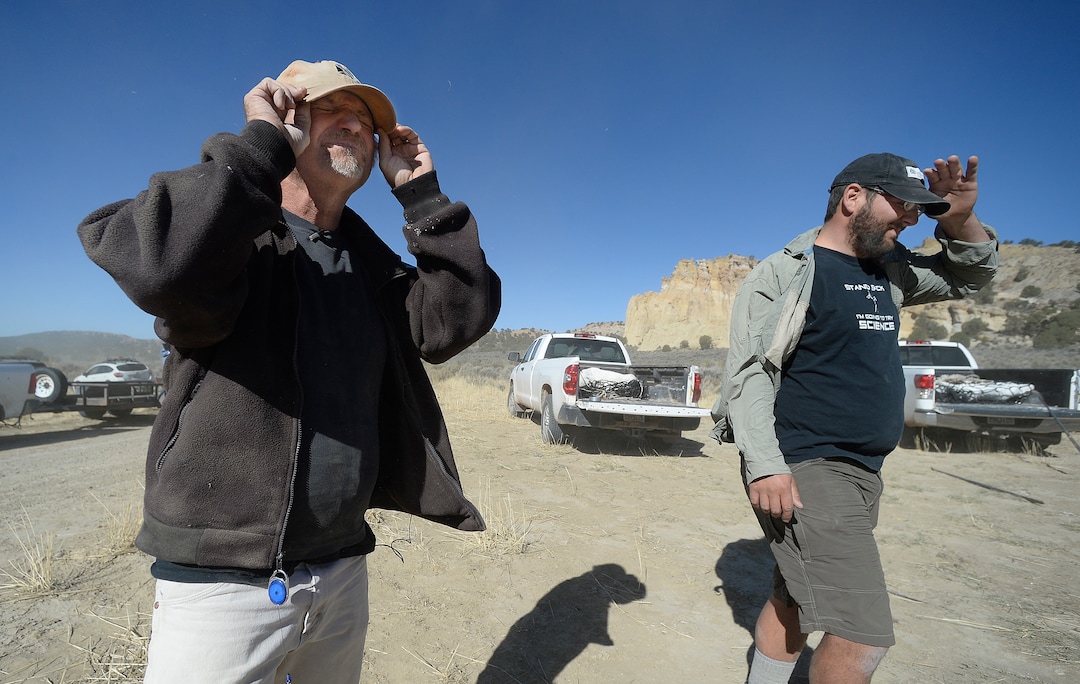 (Scott Sommerdorf   |  The Salt Lake Tribune)   
Paleontologists Alan Titus, left and Tylor Birthisel, as the helicopter carrying a load of fossilized Tyrannosaurus Rex bones nears the transport site near Tropic, Utah, Sunday, October 15, 2017. The collected pieces of the animals' skeleton were airlifted to this site from the area where the skeleton was found in 2015 by Titus.