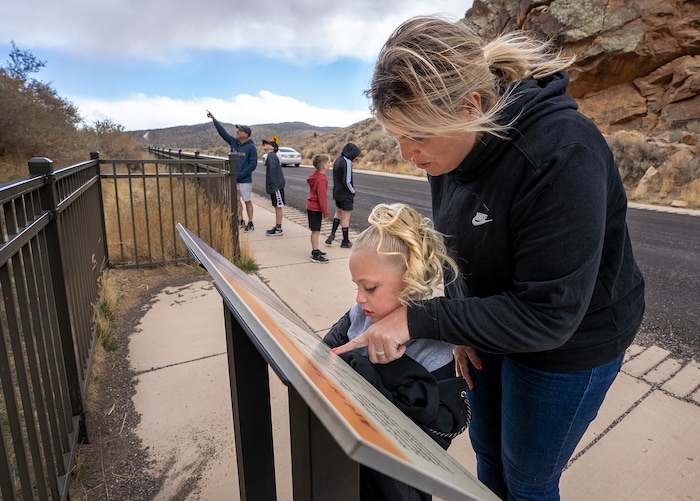 (Leah Hogsten | The Salt Lake Tribune) Annie Nielson helps her daughter Leah read the Parowan Gap information placard on a brief stop on their drive home to Spanish Fork, Mar. 20, 2021, while Jim Nielson points out petroglyphs to his son Jake while sons Alex and Ryan look at the south side of the gap.