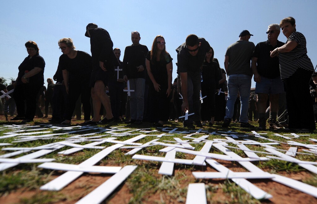 (The Associated Press) In this photo taken Oct. 30, 2017 people place white crosses, symbolically representing farmers killed in the country, at a ceremony at the Vorrtrekker Monument in Pretoria, South Africa. U.S. President Donald Trump has tweeted that he has asked the Secretary of State Mike Pompeo to "closely study the South African land and farm seizures and expropriations and the large scale killing of farmers." Trump added, "South African Government is now seizing land from white farmers."