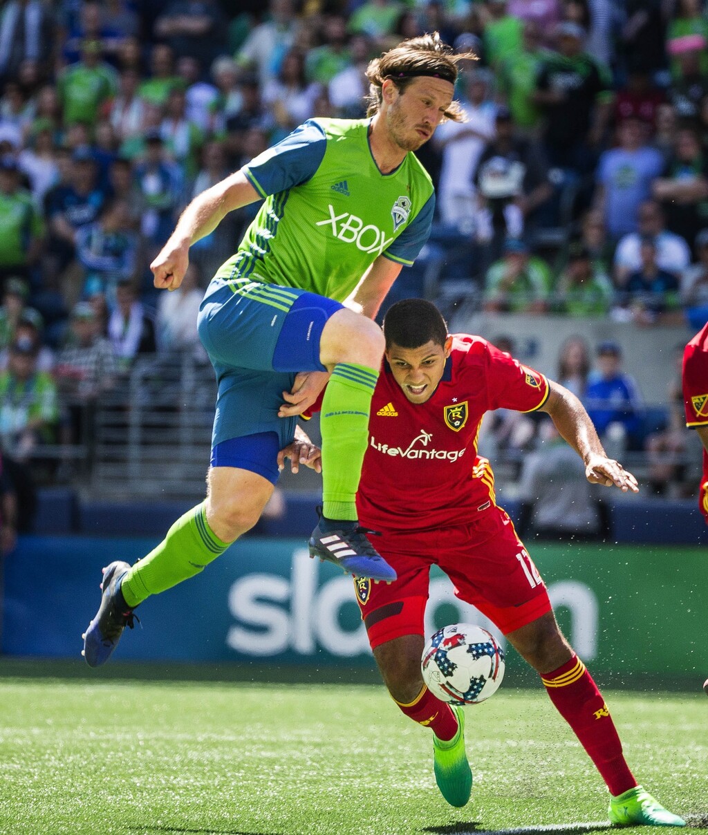 Seattle's Gustav Svensson, top, goes high and Real Salt Lake's Omar Holness goes low as they go after the ball as it reaches the top of the box on the RSL side of the field during the first half of their match in Seattle earlier this season. (Dean Ruiz/The Seattle Times via AP)