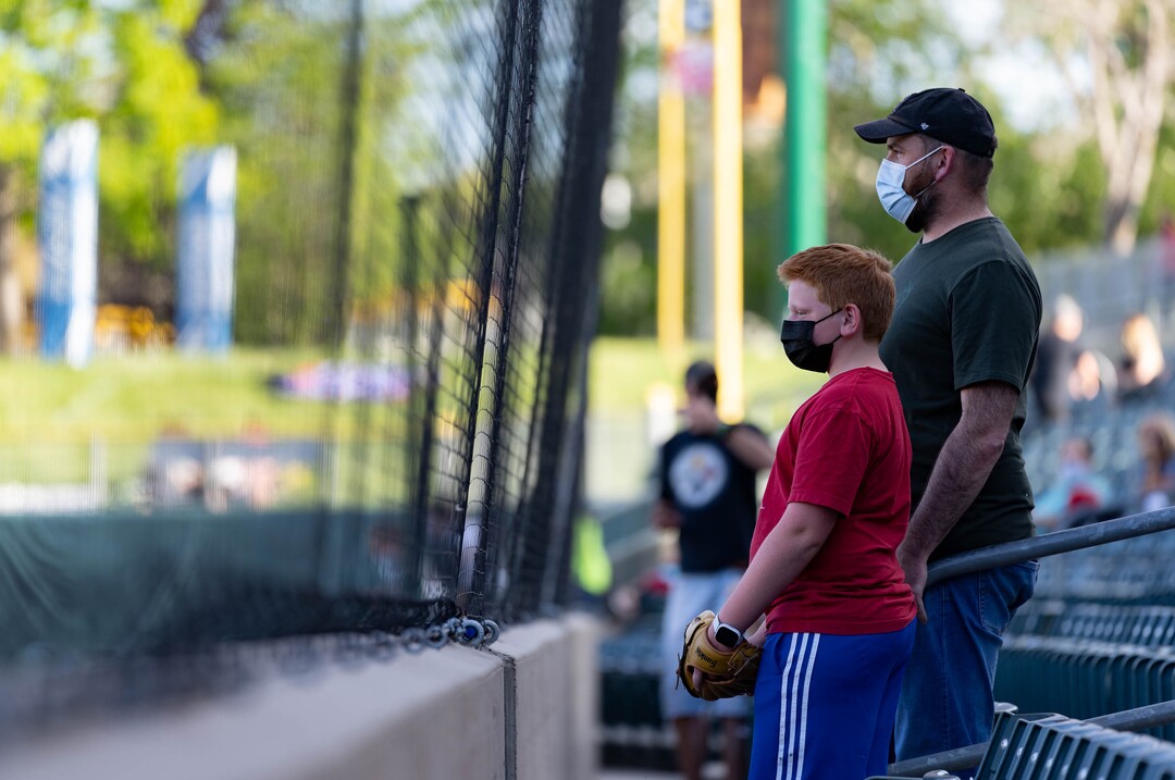 (Francisco Kjolseth | The Salt Lake Tribune) Ryan Allen and his son Calvin, 11, watch the team warm up behind the netting during the Salt Lake Bees season opener at Smith’s Ballpark Thursday night, May 6, 2021, after shutting down last season due to the pandemic.