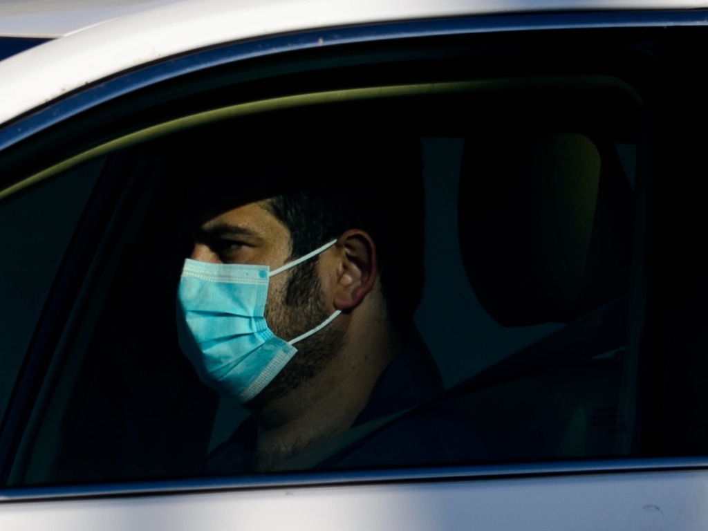 (Trent Nelson  |  The Salt Lake Tribune) A man wearing a mask drives in Ogden on Saturday, May 9, 2020.