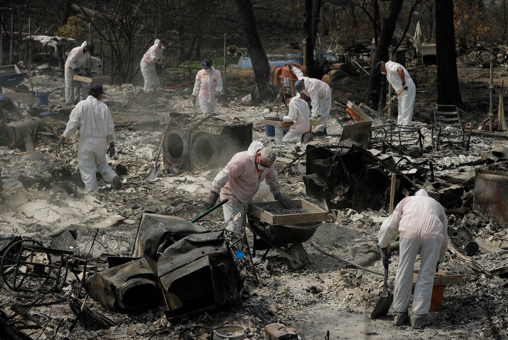 (AP Photo | John Locher) Volunteers with Samaritan's Purse sift through the charred remains of a home burned in the Carr Fire, Friday, Aug. 10, 2018, in Redding, Calif.