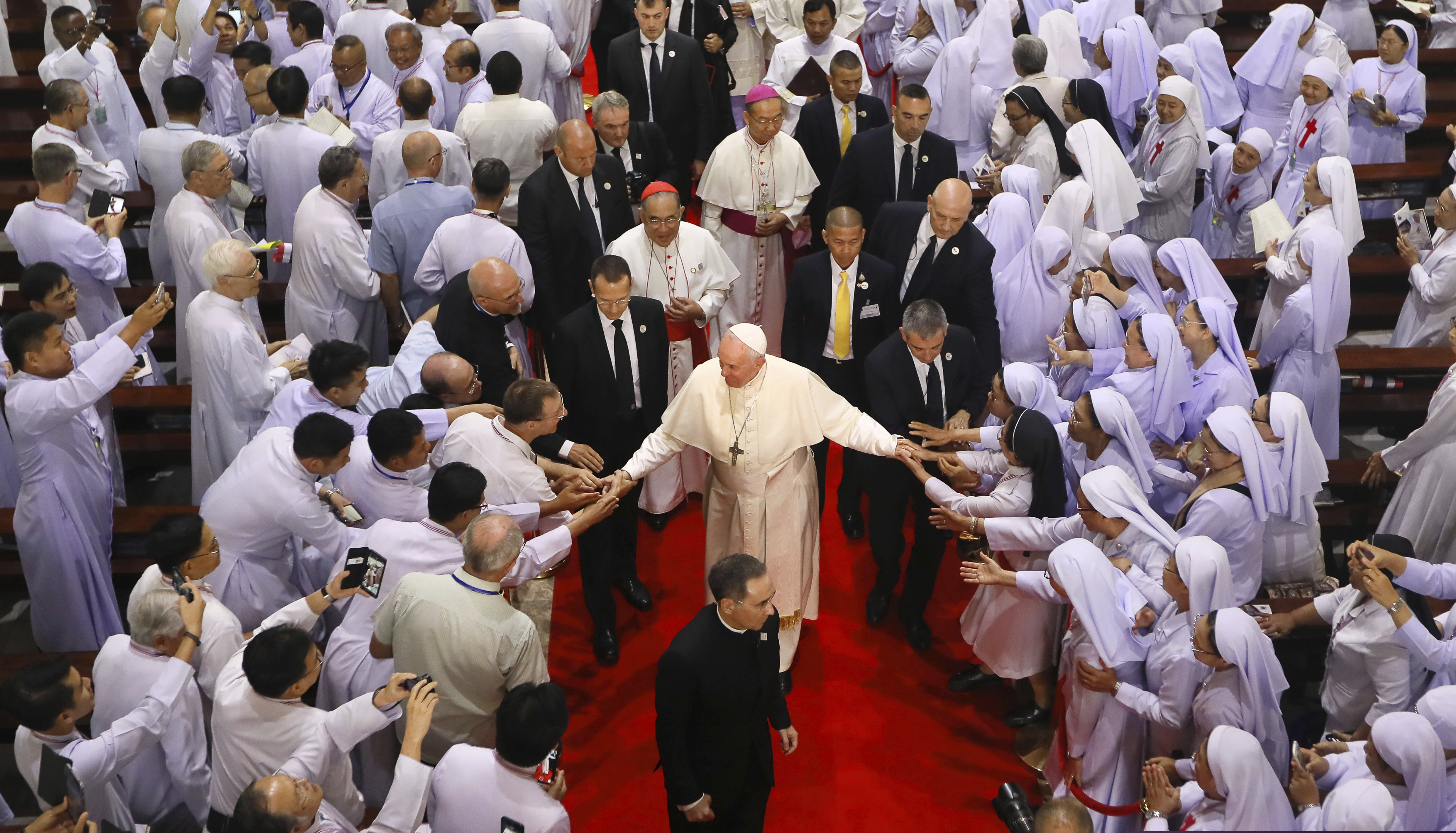 (Manish Swarup | The Associated Press) Priests, religious seminarians and Catechists touch the hands of Pope Francis as he leaves after meeting them at St. Peter's Parish on the outskirts of Bangkok, Thailand, Friday, Nov. 22, 2019. Pope Francis urged more efforts to combat the "humiliation" of women and children forced into prostitution as he began a busy visit Thursday to Thailand, where human trafficking and poverty help fuel the sex tourism industry.