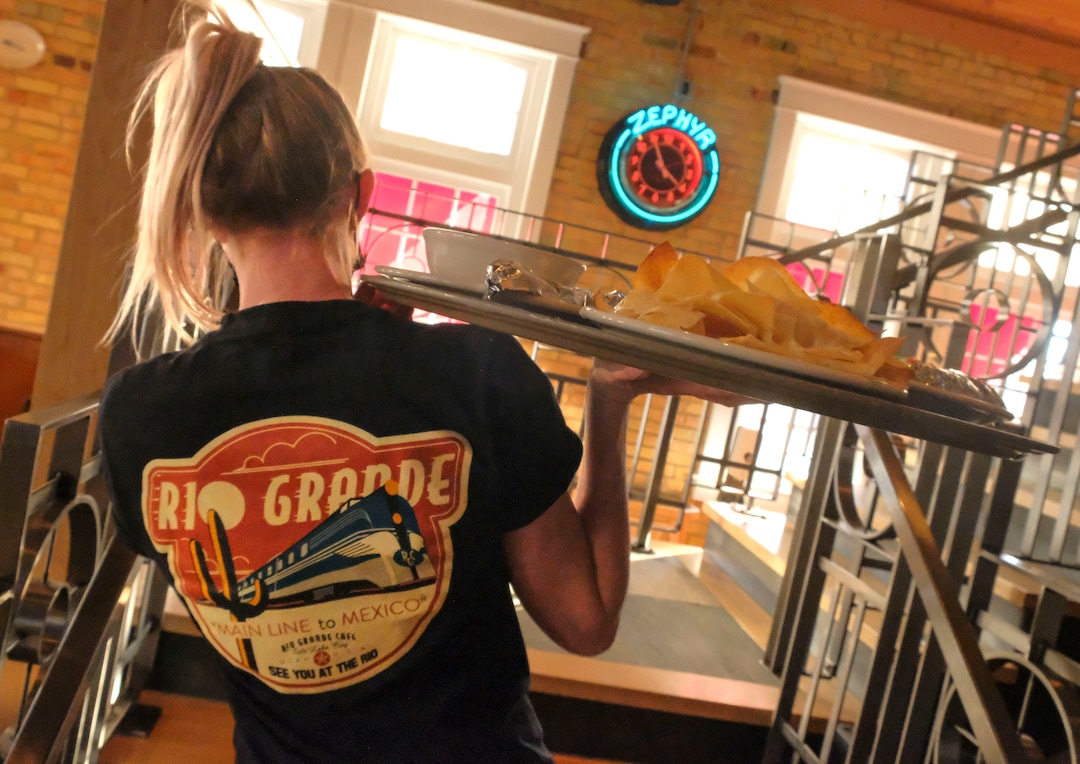 (Leah Hogsten  |  The Salt Lake Tribune) Server Kayla Adams carries a tray of Rio Grande Cafe's plates on Tuesday. Salt Lake City's popular Rio Grande Cafe, which has been closed since March due to the pandemic and the earthquake, has moved to its new location near the University of Utah on 1300 East, Dec. 29, 2020.