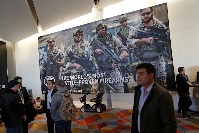 People walk through halls outside of the SHOT Show gun show Wednesday, Jan. 24, 2018, in Las Vegas. (AP Photo/John Locher)