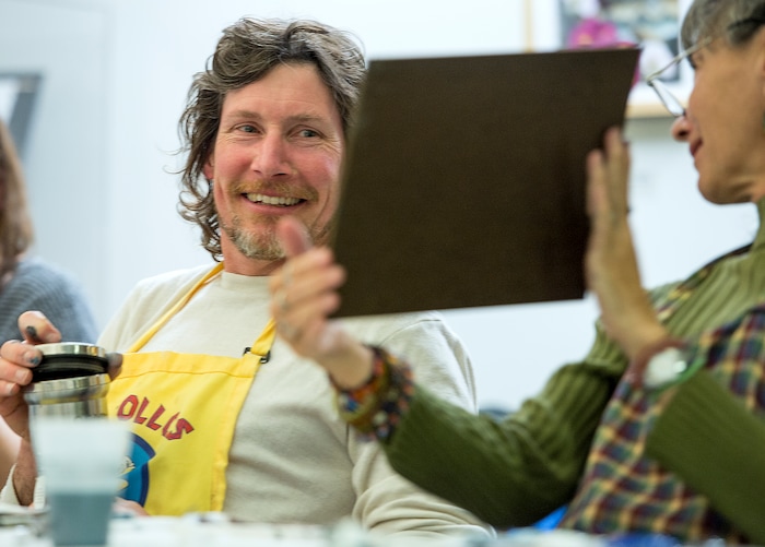 (Leah Hogsten  |  The Salt Lake Tribune) Patrick Watson, left, shares a smile with his friend Nia Sherar as she shows him her winter scene painting during their Bob Ross Paint-Along class, Saturday, Jan. 6, 2018, at the Salt Lake City Public Library's Sweet Branch in the Avenues.