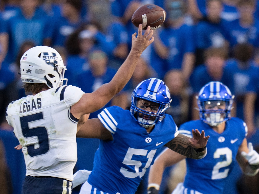 (Rick Egan | The Salt Lake Tribune) Brigham Young Cougars defensive lineman Alden Tofa (51) defends as Utah State Aggies quarterback Cooper Legas (5) throws the ball, in Football action between the Brigham Young Cougars and the Utah State Aggies, at LaVell Edwards Stadium in Provo, on Thursday, Sept. 29, 2022.