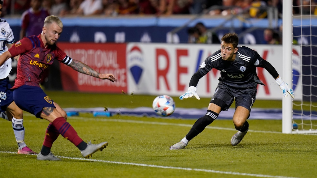 (Rick Bowmer | AP) Vancouver Whitecaps goalkeeper Thomas Hasal defends as Real Salt Lake midfielder Albert Rusnak strikes the ball during the second half of an MLS soccer match Wednesday, July 7, 2021, in Sandy.