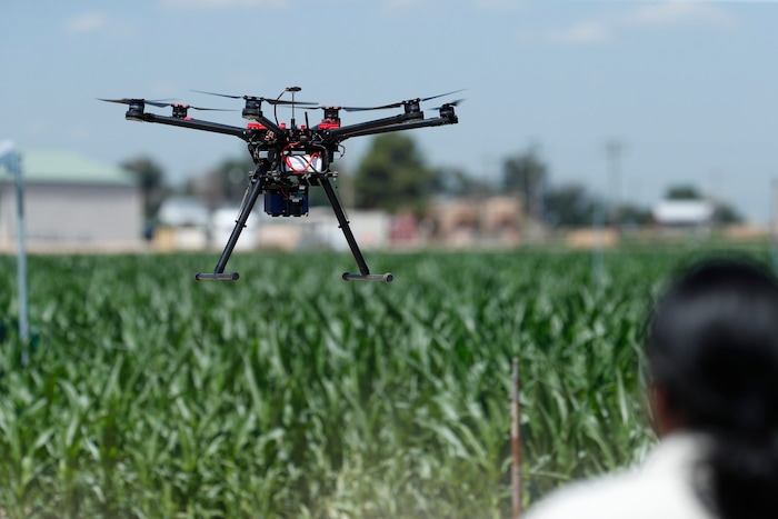 (David Zalubowski | AP Photo) In this Thursday, July 11, 2019, photograph, United States Department of Agriculture engineering technician Kevin Yemoto guides a drone into the air at a research farm northeast of Greeley, Colo. Researchers are using drones carrying imaging cameras over the fields in conjunction with stationary sensors connected to the internet to chart the growth of crops in an effort to integrate new technology into the age-old skill of farming.