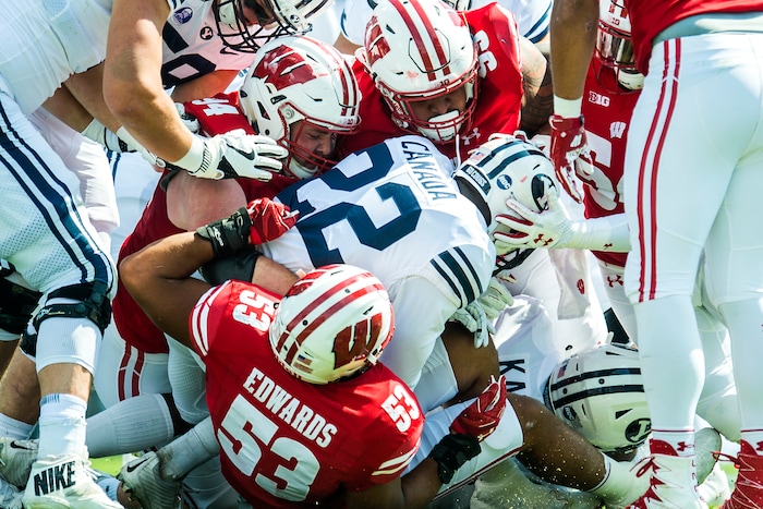 (Chris Detrick  |  The Salt Lake Tribune)   Wisconsin Badgers linebacker T.J. Edwards (53) Wisconsin Badgers defensive end Conor Sheehy (94) Wisconsin Badgers nose tackle Olive Sagapolu (99) and Wisconsin Badgers linebacker Chris Orr (54) tackle Brigham Young Cougars running back Squally Canada (22) during the game at LaVell Edwards Stadium Saturday Saturday, September 16, 2017. Wisconsin Badgers are leading Brigham Young Cougars 24-6 at halftime.