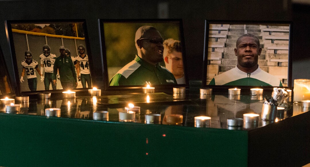 (Rick Egan  |  The Salt Lake Tribune)Photos of Hillcrest football coach is surrounded by candles, at a candlelight vigil in honor of coach Cazzie Brown, at Hillcrest High School, Monday, August 28, 2017.