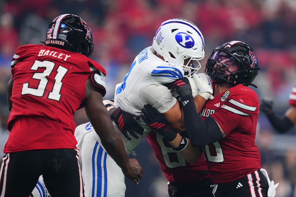 (Julio Cortez | AP) BYU running back LJ Martin (4) is stopped by a trio of Texas Tech defenders in last year's Big 12 title game. 