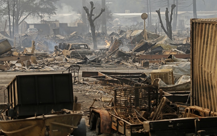 Cars sit among the debris at the Journey's End mobile home park on Monday, Oct. 9, 2017, in Santa Rosa, Calif. Wildfires whipped by powerful winds swept through Northern California early Monday, sending residents on a headlong flight to safety through smoke and flames as homes burned. (AP Photo/Ben Margot)