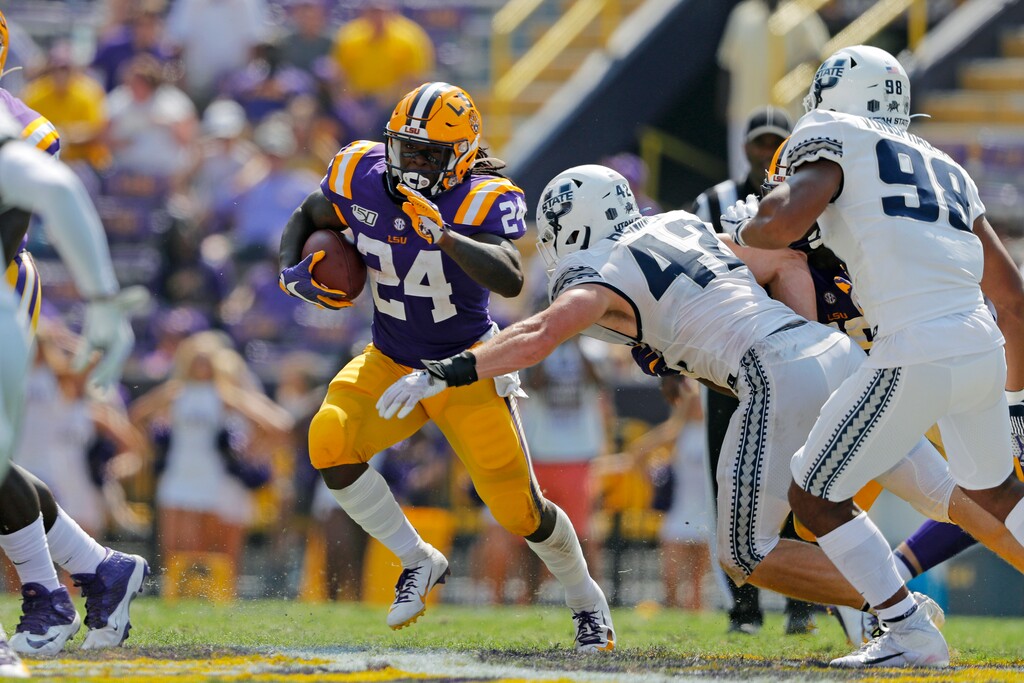 LSU running back Chris Curry (24) carries against Utah State defensive end Nick Heninger (42) in the second half of an NCAA college football game in Baton Rouge, La., Saturday, Oct. 5, 2019. (AP Photo/Gerald Herbert)