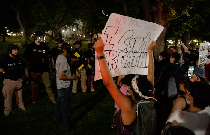 (Francisco Kjolseth  |  The Salt Lake Tribune) Protesters walk down State Street in Salt Lake City trying to engage with police momentarily as police line up to enforce a mandatory curfew on Monday, June 1, 2020, following violence and unrest over the weekend due to the death of George Floyd by police.