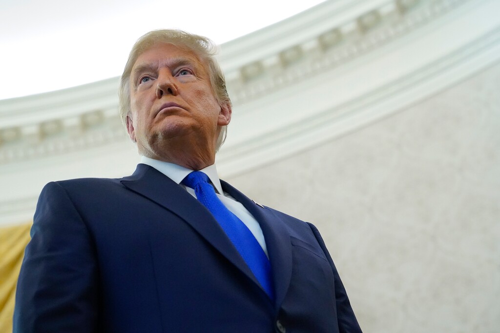 (AP Photo/Patrick Semansky) President Donald Trump listens to a reporter's question after awarding the Presidential Medal of Freedom, the highest civilian honor, to Olympic gold medalist and former University of Iowa wrestling coach Dan Gable in the Oval Office of the White House, Monday, Dec. 7, 2020, in Washington.