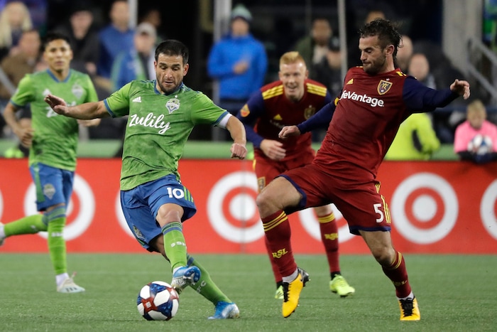 Seattle Sounders forward Nicolas Lodeiro, left, is challenged by Real Salt Lake midfielder Kyle Beckerman (5) during the first half of an MLS Western Conference semifinal playoff soccer match Wednesday, Oct. 23, 2019, in Seattle. (AP Photo/Ted S. Warren)