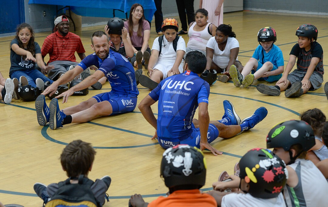(Francisco Kjolseth  |  The Salt Lake Tribune)  As part of UnitedHealthcare's Pro Cycling team and community outreach program to keep kids healthy and active, team cyclists Jonny Clarke, left, and Sebastian Haedo engage the kids in a few warm up routines before getting on the bike.In advance to the upcoming Tour of Utah bicycle race, more than 50 Salt Lake City-area kids received a new bicycle helmet at the Capitol West Boys & Girls Club on Tuesday, July 31, 2018. 